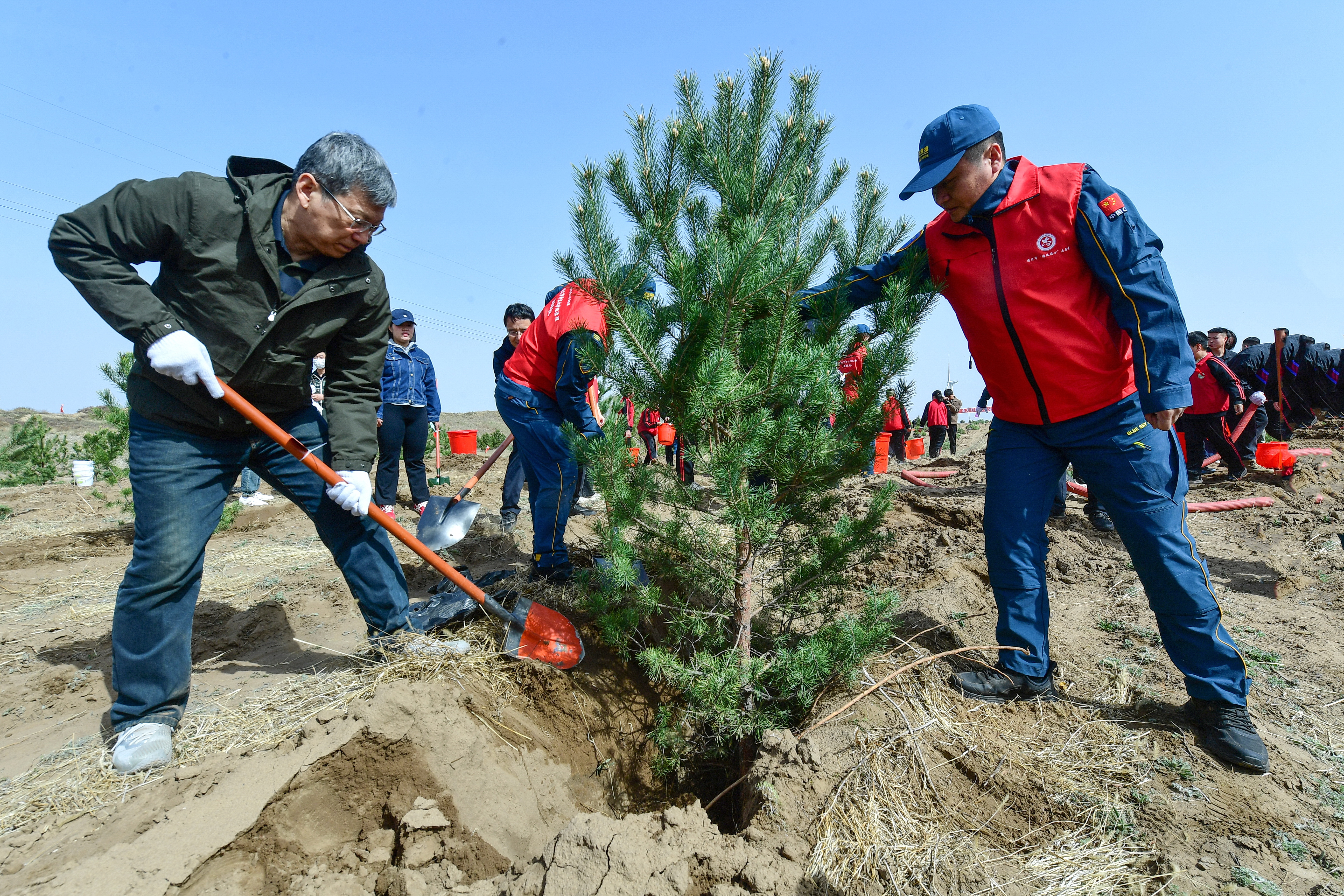 孟宪东（左一）与干部群众一起参加义务植树活动。.jpg